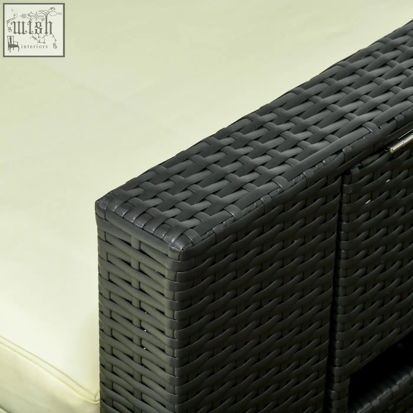 Black woven wicker outdoor storage cabinet with cream cushion near two reclining chairs and two storage footstools