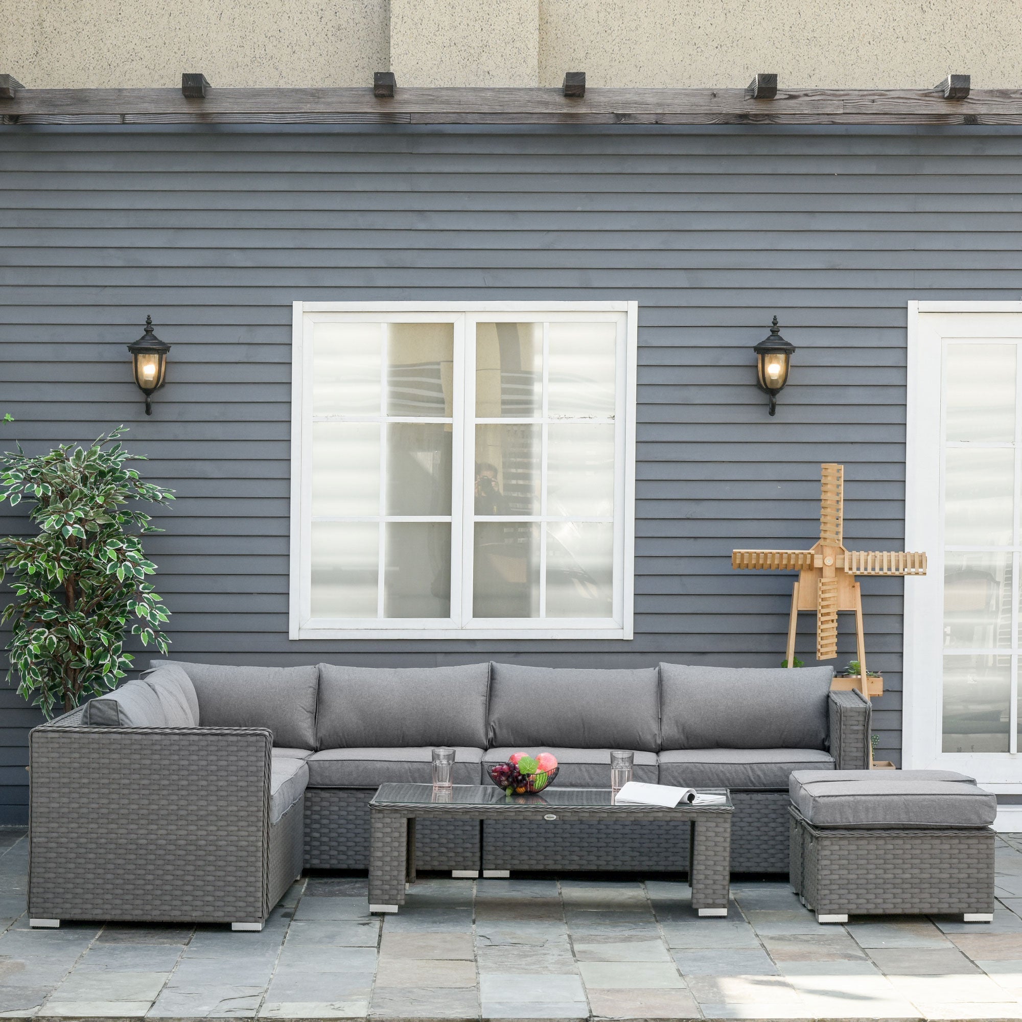 Gray woven wicker double corner sofa set with padded cushions and glass top coffee table for outdoor use