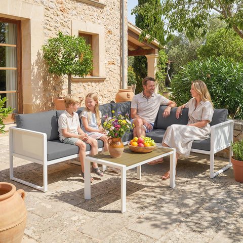 Modern white metal garden furniture set with gray cushions and faux wood table perfect for outdoor seating