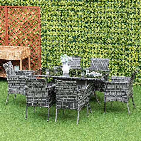 Gray woven wicker dining set with glass top table and six cushioned armchairs perfect for garden furniture