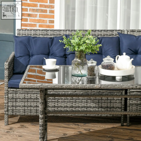 Gray wicker outdoor coffee table with glass top and navy blue cushioned seating in rust-resistant metal corner sofa set