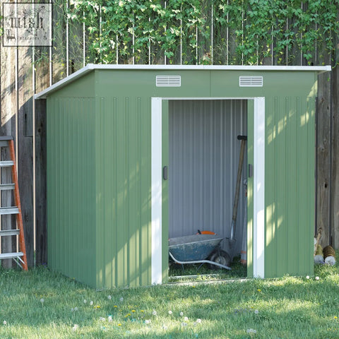 Green metal storage shed with white trim slanted roof and sliding door includes foundation kit for backyard use