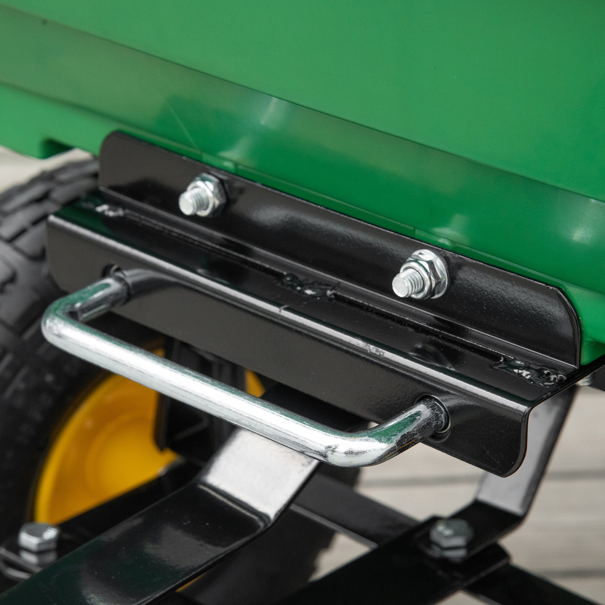 Black metal hitch with silver bolts and chrome handle attached to green outsunny garden cart for heavy duty use