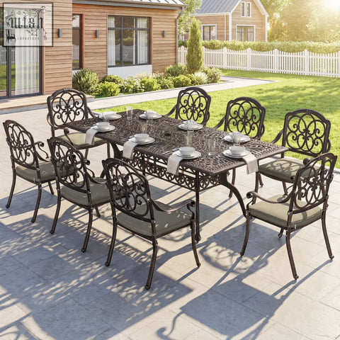 Black wrought iron cast aluminium garden dining set with ornate scrollwork and gray cushioned seats for patio