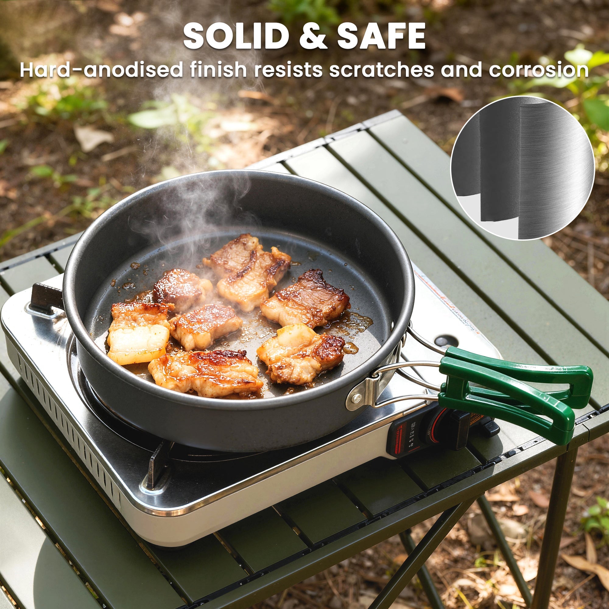 Black hard-anodized frying pan with green anti-scald handle on portable stove from Outsunny camping cooking set