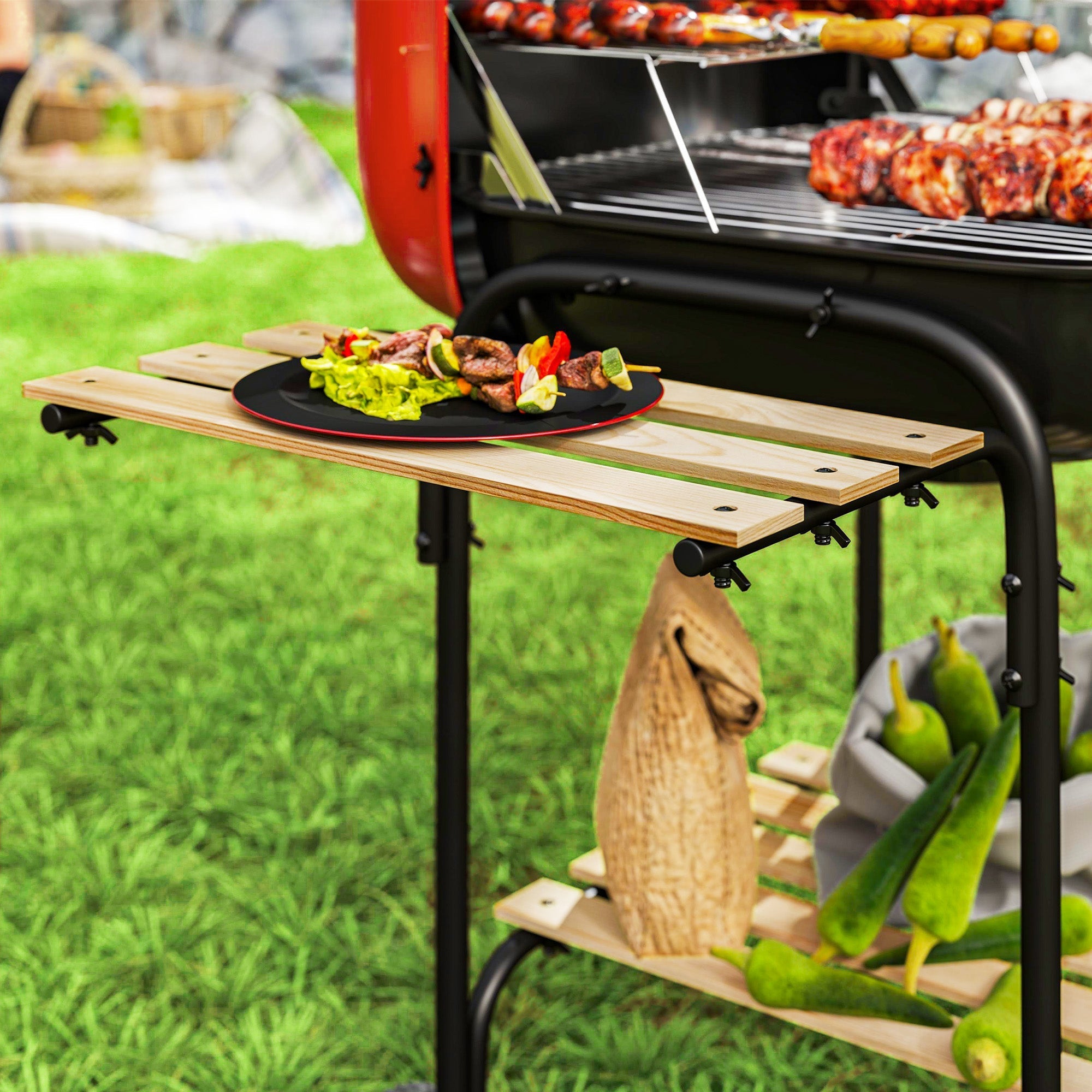 A rustic wooden outdoor grill cart with black metal legs holding fresh okra beside a red portable bbq with grill grate and warming rack