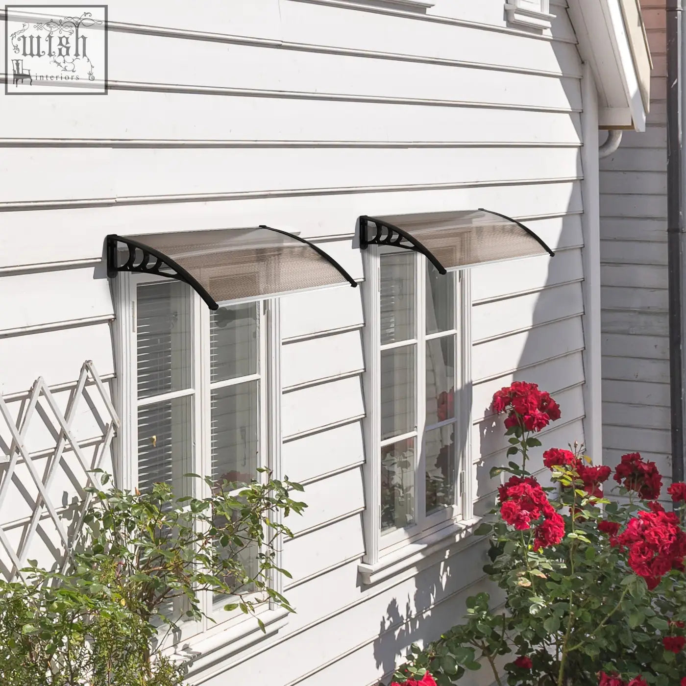 Black metal door canopy with transparent curved rigid plastic cover and rigid plastic frame above two windows on white house