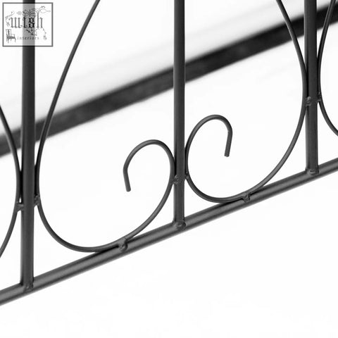 Black wrought iron garden fence with ornate scrollwork design for patio decoration and fence features ground edging