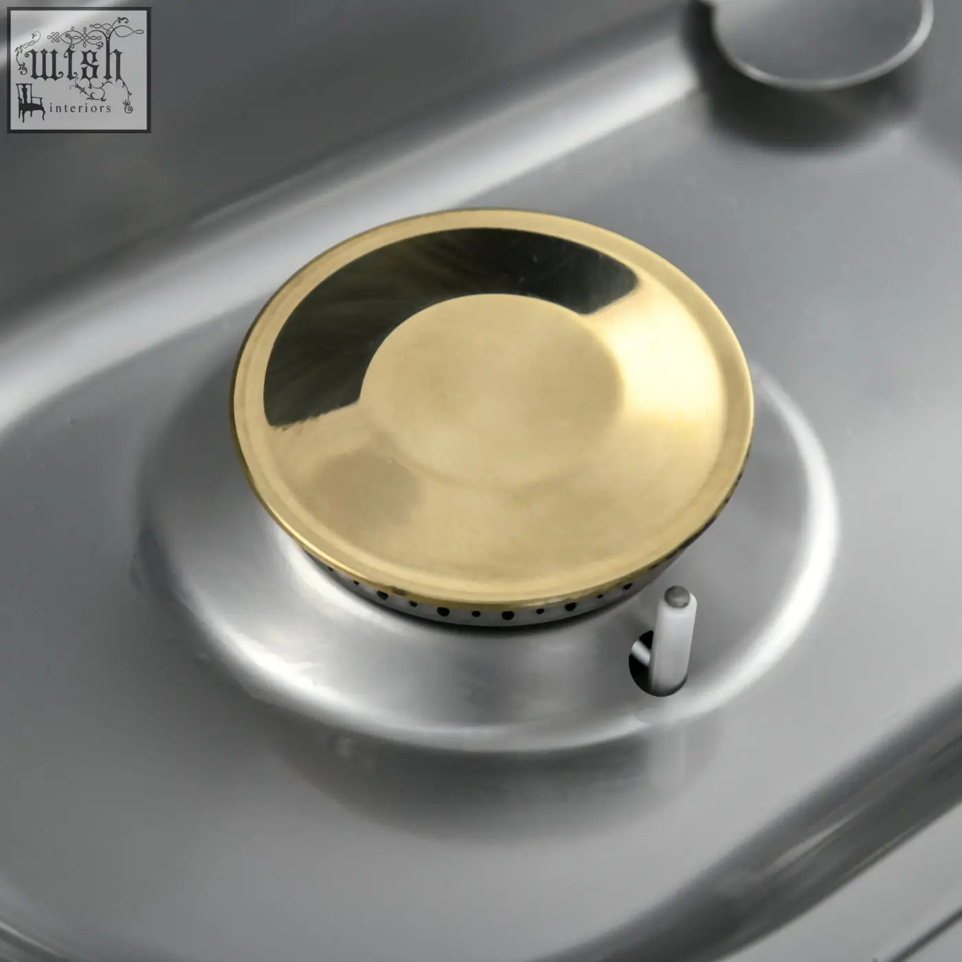 Gold-colored burner cap with polished metal finish on stainless steel cooktop of outsunny two gas bbq grill with piezo ignition