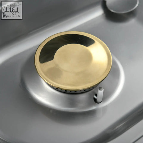 Gold-colored burner cap with polished metal finish on stainless steel cooktop of outsunny two gas bbq grill with piezo ignition