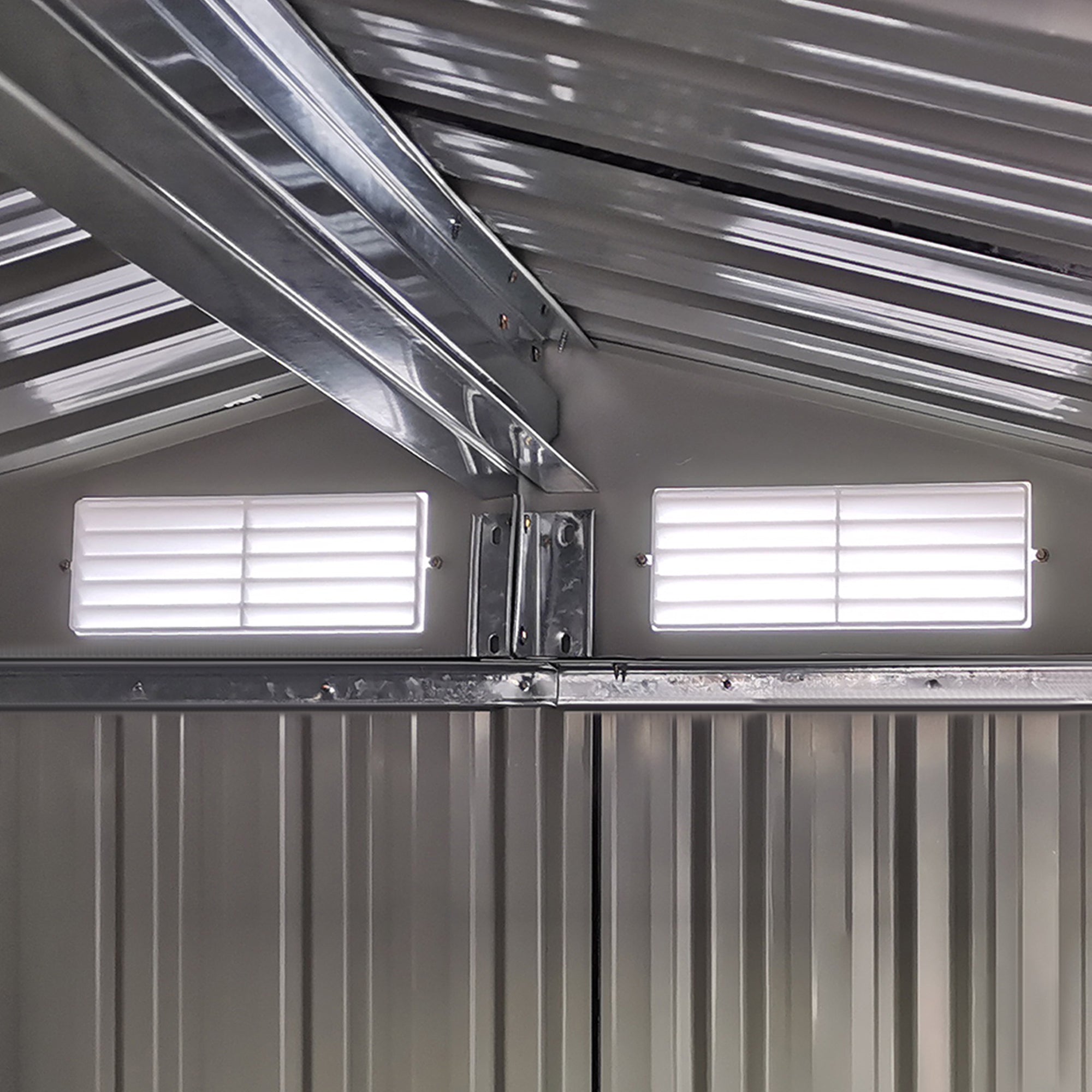 Silver corrugated metal roof with two louvered vents on grey outsunny garden metal tool storage shed with sliding door and foundation kit