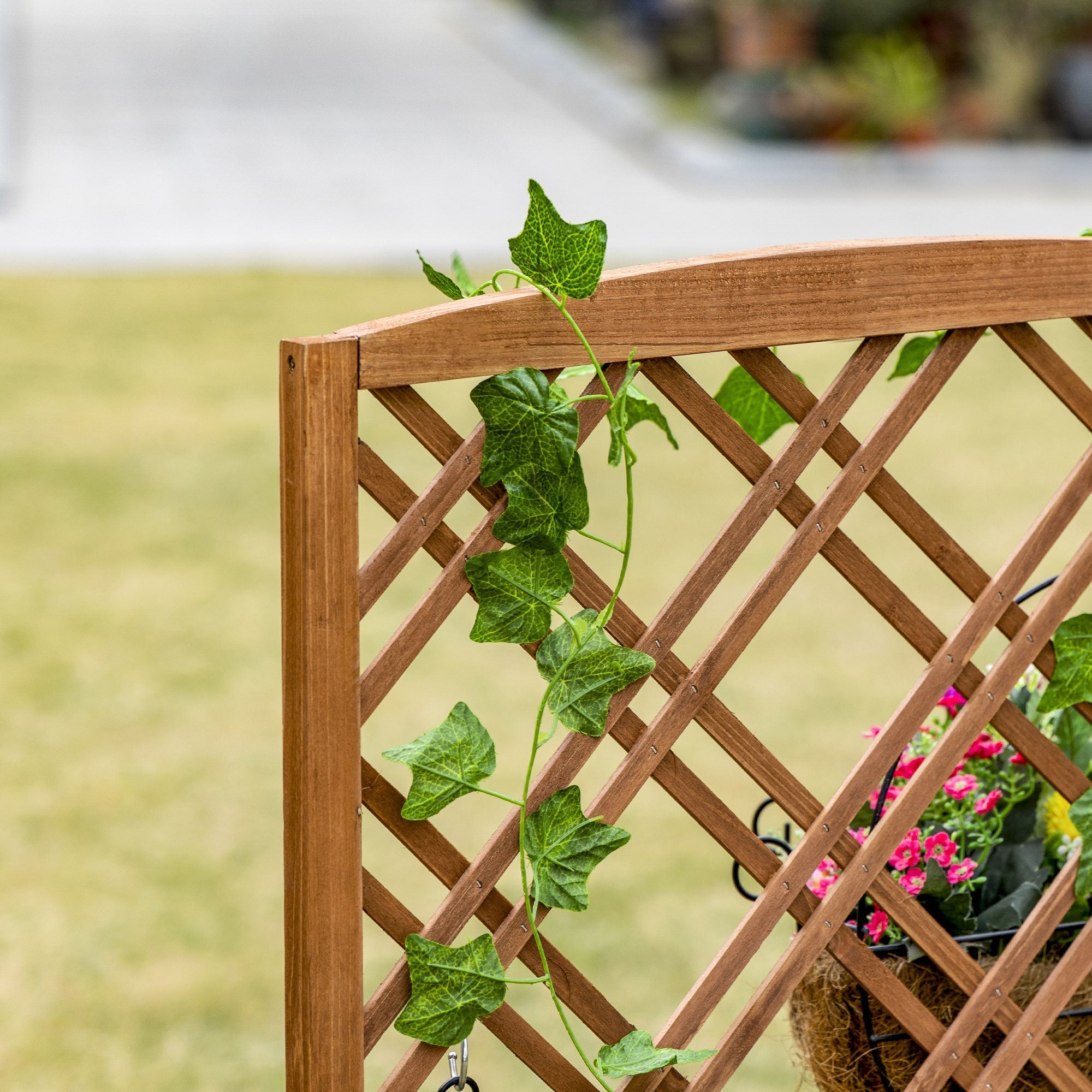 Outsunny brown fir wood garden bed with lattice trellis and green ivy vines climbing its diagonal slats