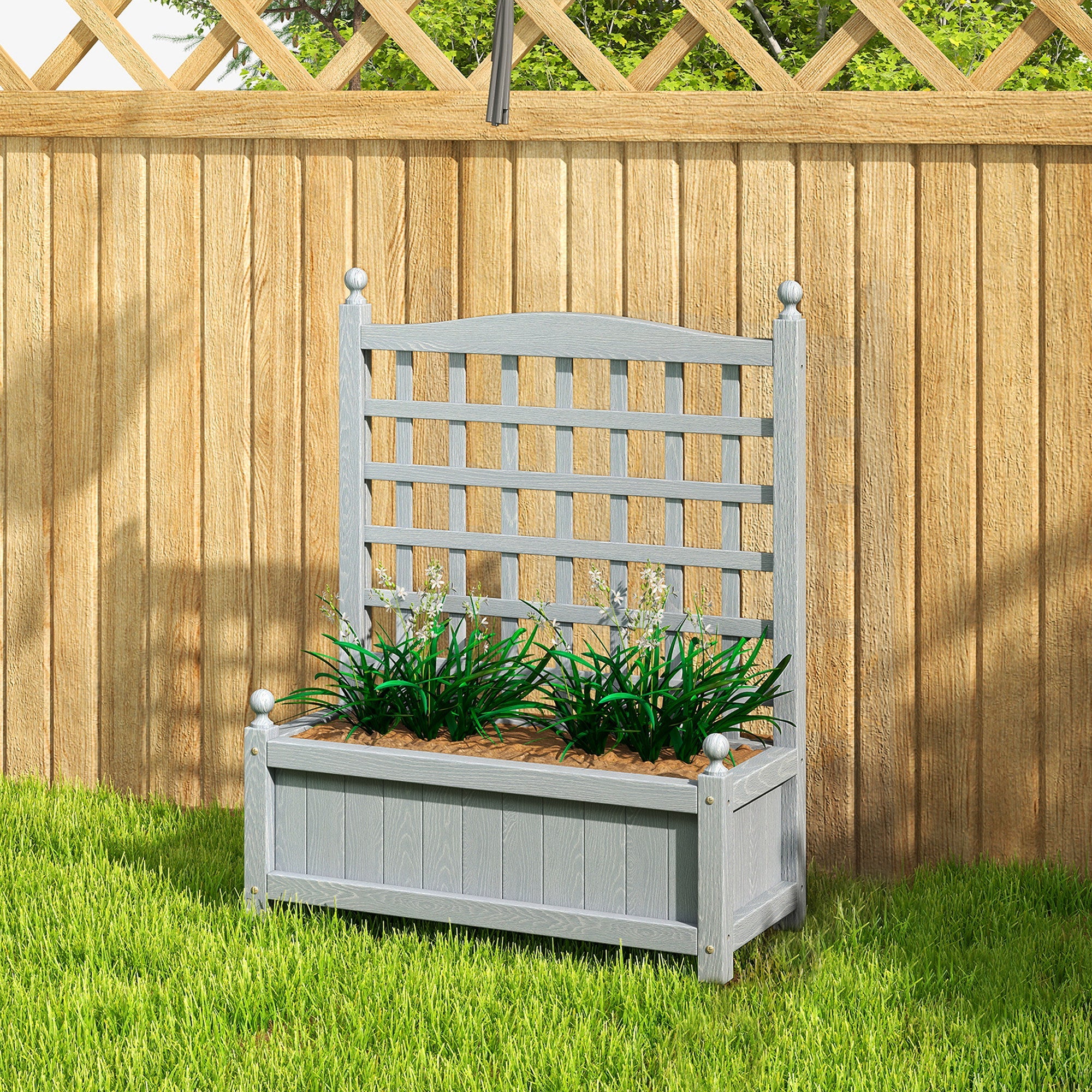 Gray wooden outsunny garden planter with lattice top two leakage holes filled with green plants and brown soil