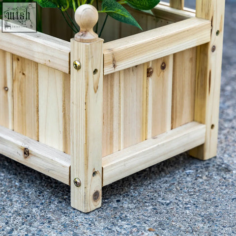 Light-colored wooden outsunny garden planter with vertical slats and two leakage holes for climbing plants