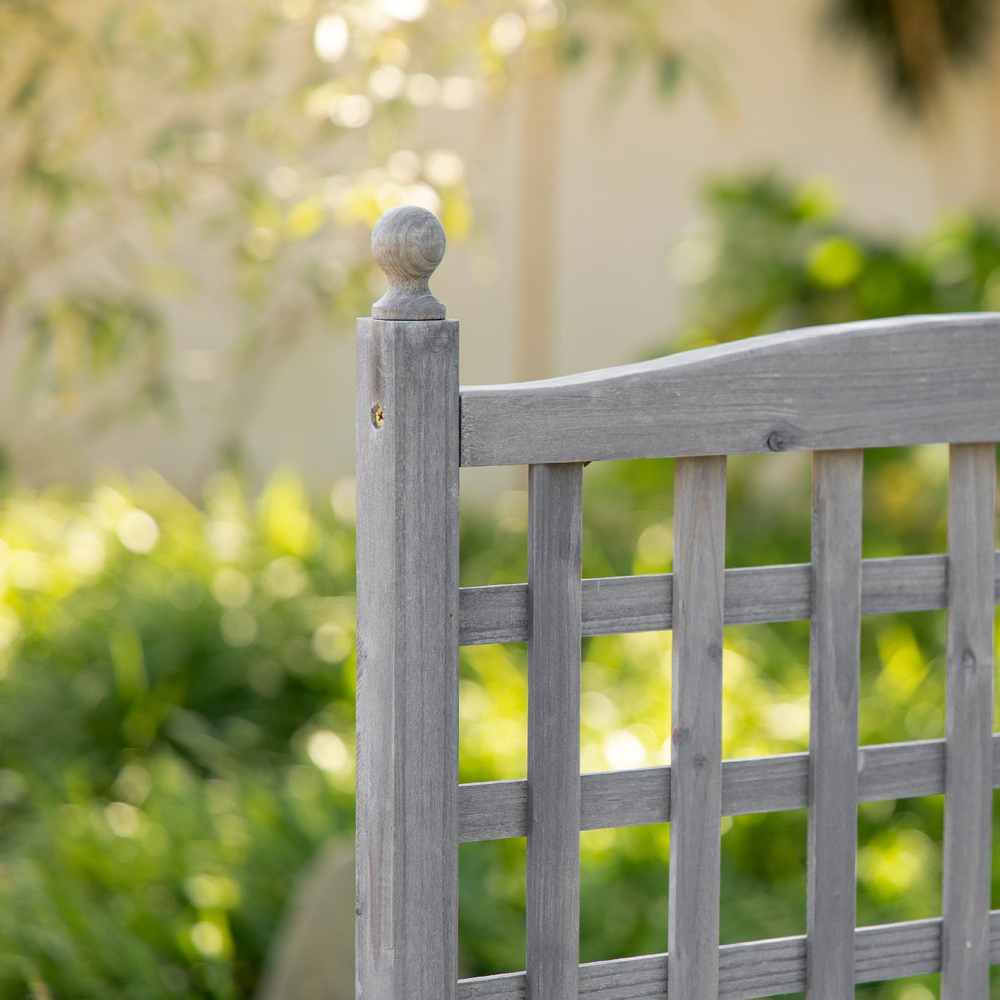 Gray wooden garden planter with trellis and rounded top cap featuring two leakage holes for climbing vines