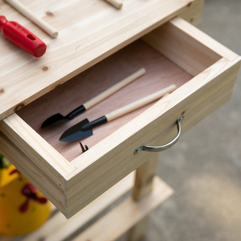 Light wooden drawer with silver handle holding two black gardening trowels in outsunny garden potting bench table