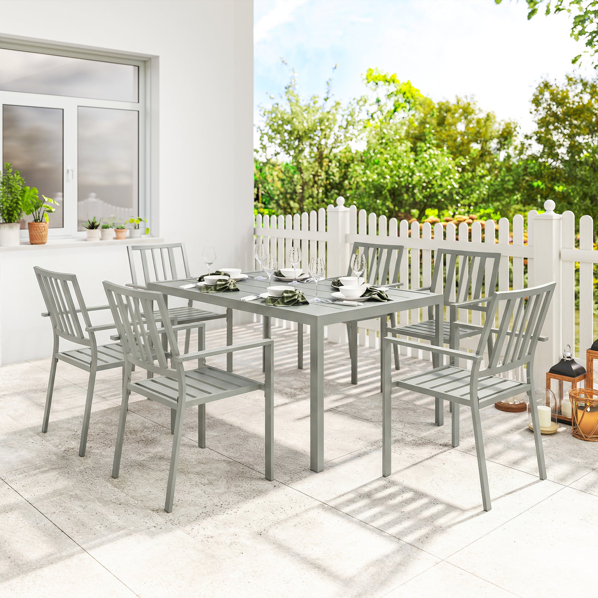 Gray galvanised steel garden table set with six stackable chairs and umbrella hole for outdoor dining