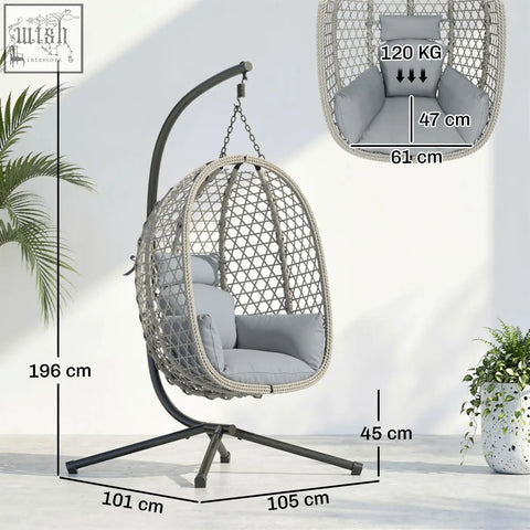 Gray woven wicker hanging egg chair with plush cushion and black metal stand featuring safety strap and foldable basket