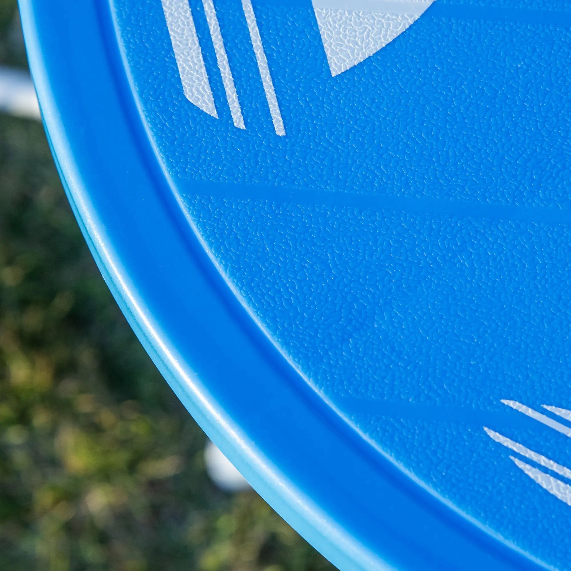 Bright blue plastic frisbee with textured surface and white geometric logo included with outsunny kids outdoor bistro set with shark design and sun umbrella