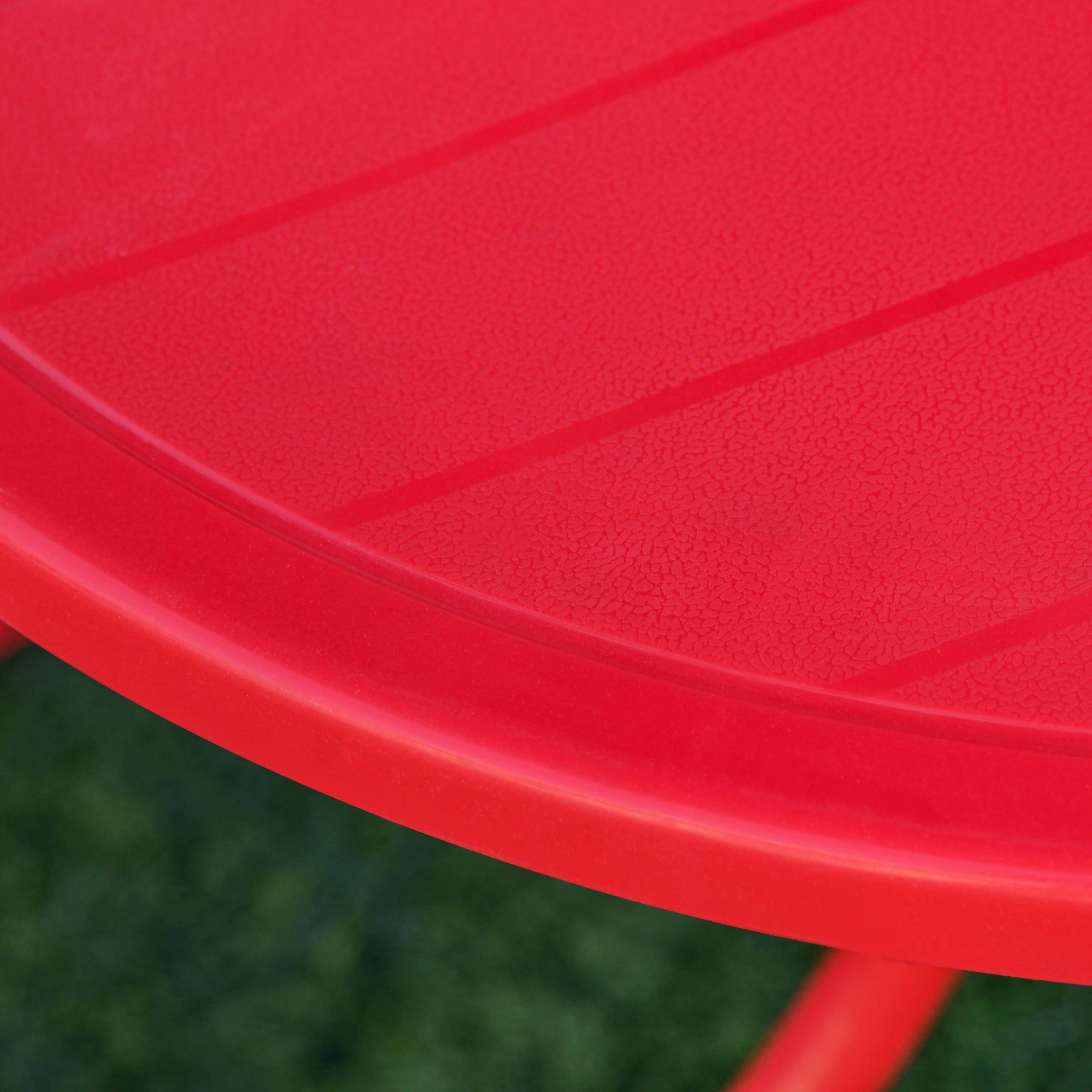 Bright red plastic tabletop with textured surface and subtle diagonal ridges on outsunny kids outdoor table with sun umbrella