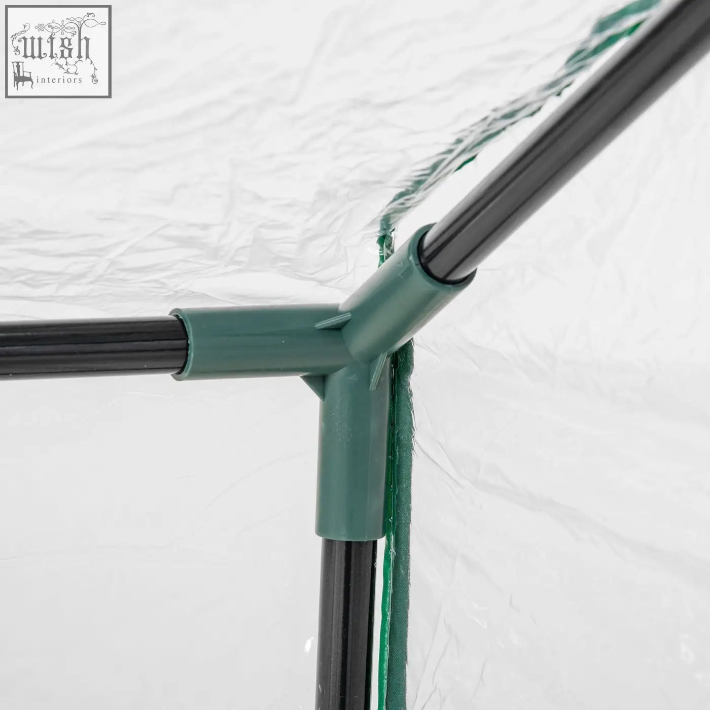 Green plastic corner joint connecting three black poles in outsunny mini greenhouse with plastic cover and zipped windows