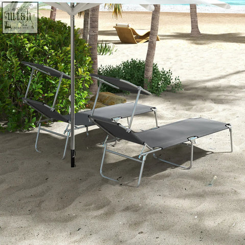 Two gray fabric reclining sun loungers with metal frames and sun shade awning on a sandy beach by outsunny