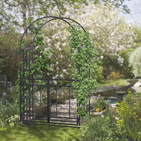 Dark grey metal garden arbor with lush green ivy climbing plants on curved frame and double gates for outdoor use