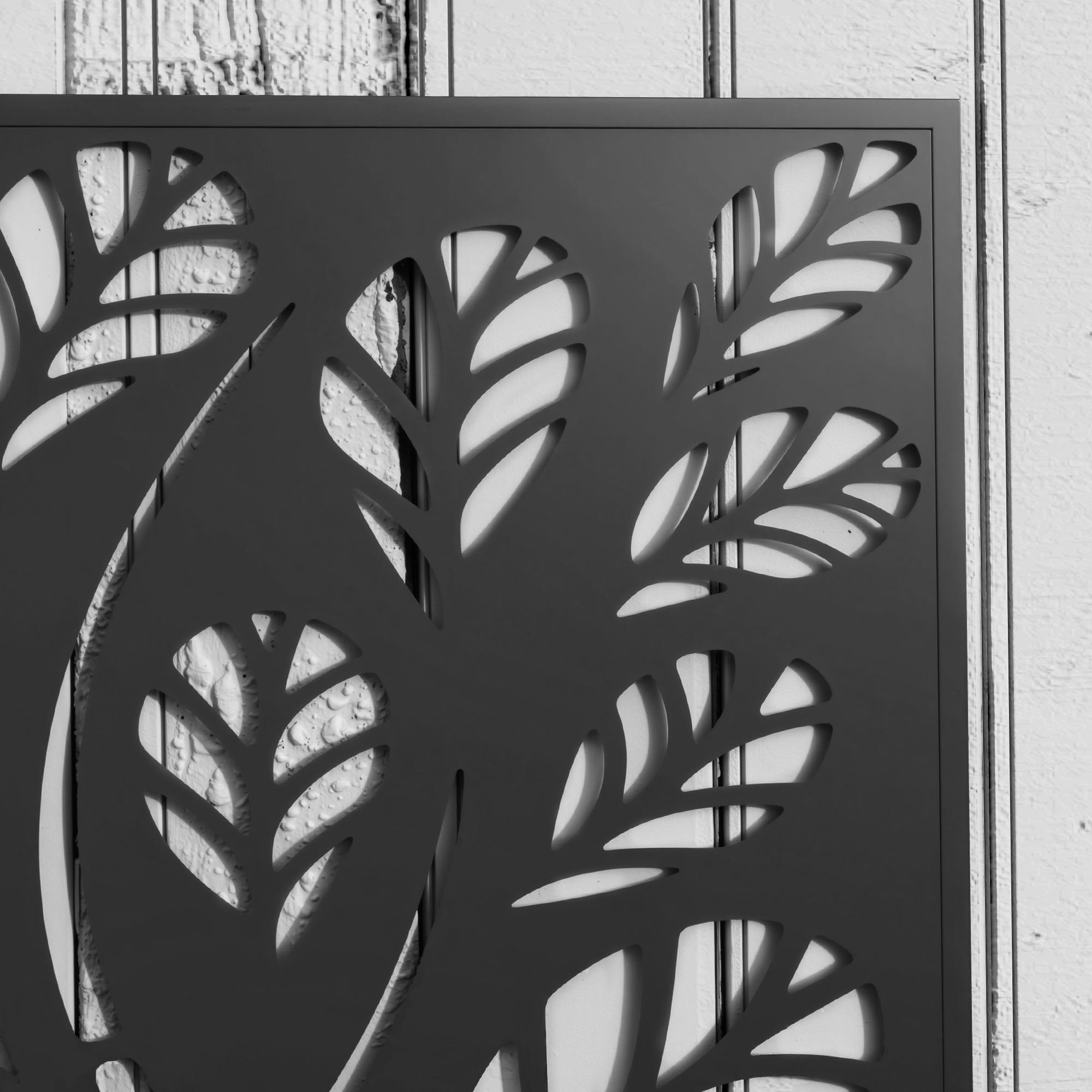 Black powder coated metal planter with intricate leaf cut-out trellis for outdoor use by Outsunny