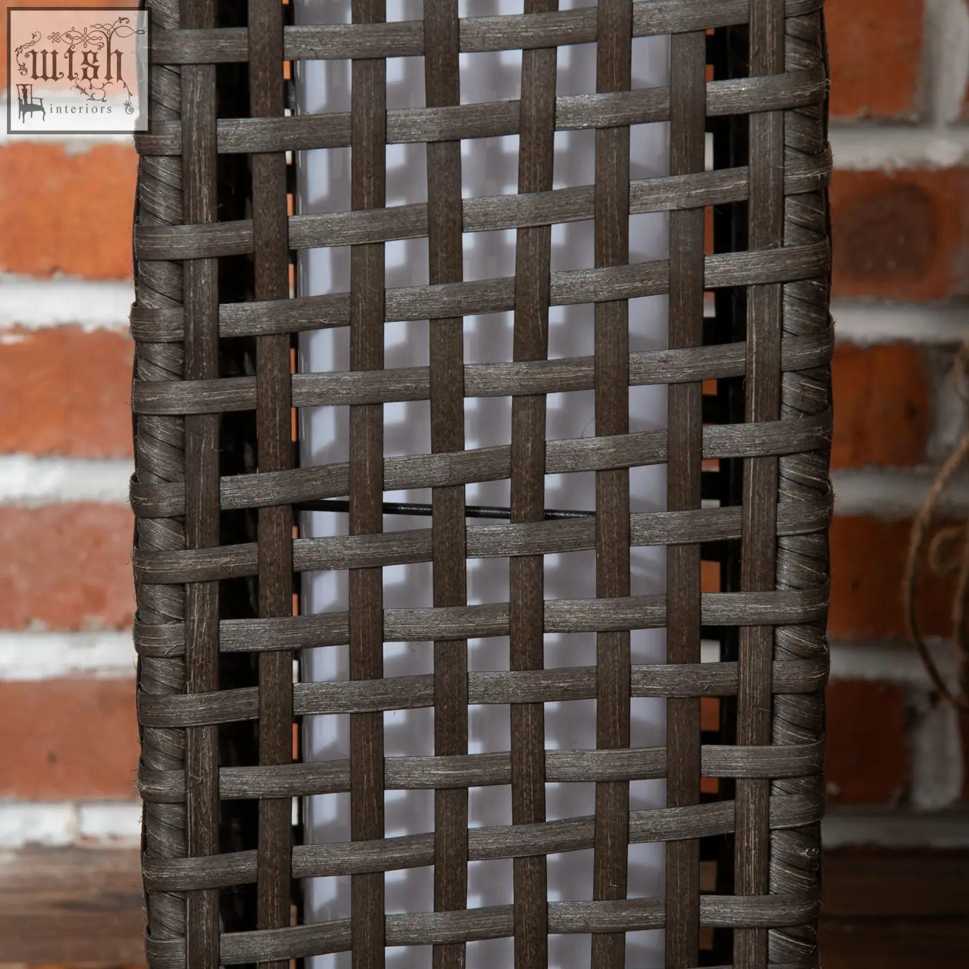 Dark brown woven wicker chair backrest with tight grid pattern next to outsunny rattan lamp with eight hours light