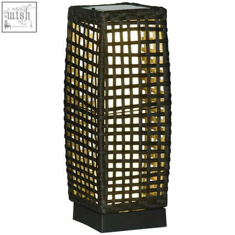 Black woven rattan lamp with solar panel and warm yellow light glows through grid for eight hours outdoor use