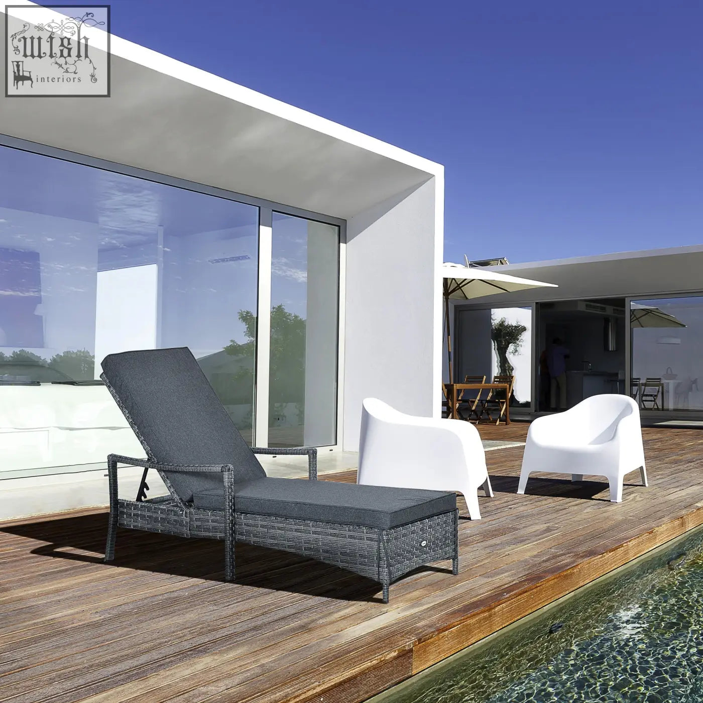 Dark gray wicker lounge chair with mixed grey rattan and seat cushion on wooden deck by pool outdoors