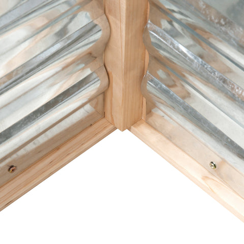 Light-colored wooden corner frame with corrugated metal panels in outsunny cold frame garden bed with greenhouse top