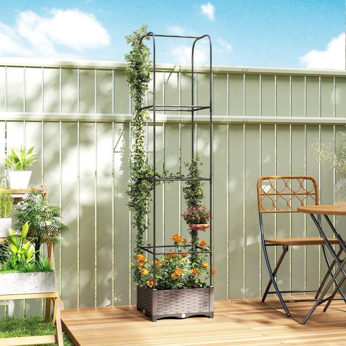 Black metal garden trellis with woven gray wicker base and climbing vines on outsunny raised garden bed with drainage