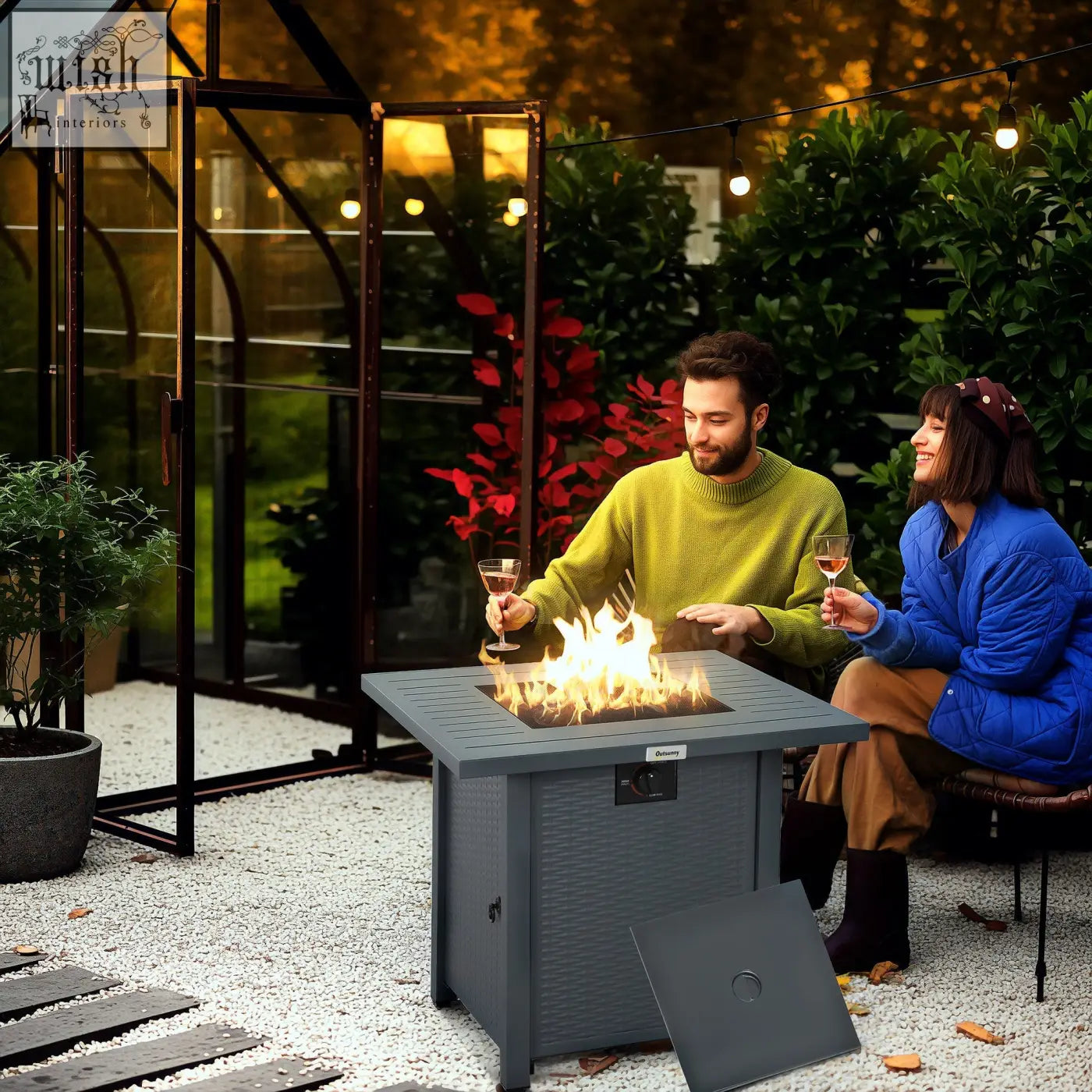 Gray outsunny rattan-style pit table with 40000 btu burner lit flame mesh guard and textured surface outdoors