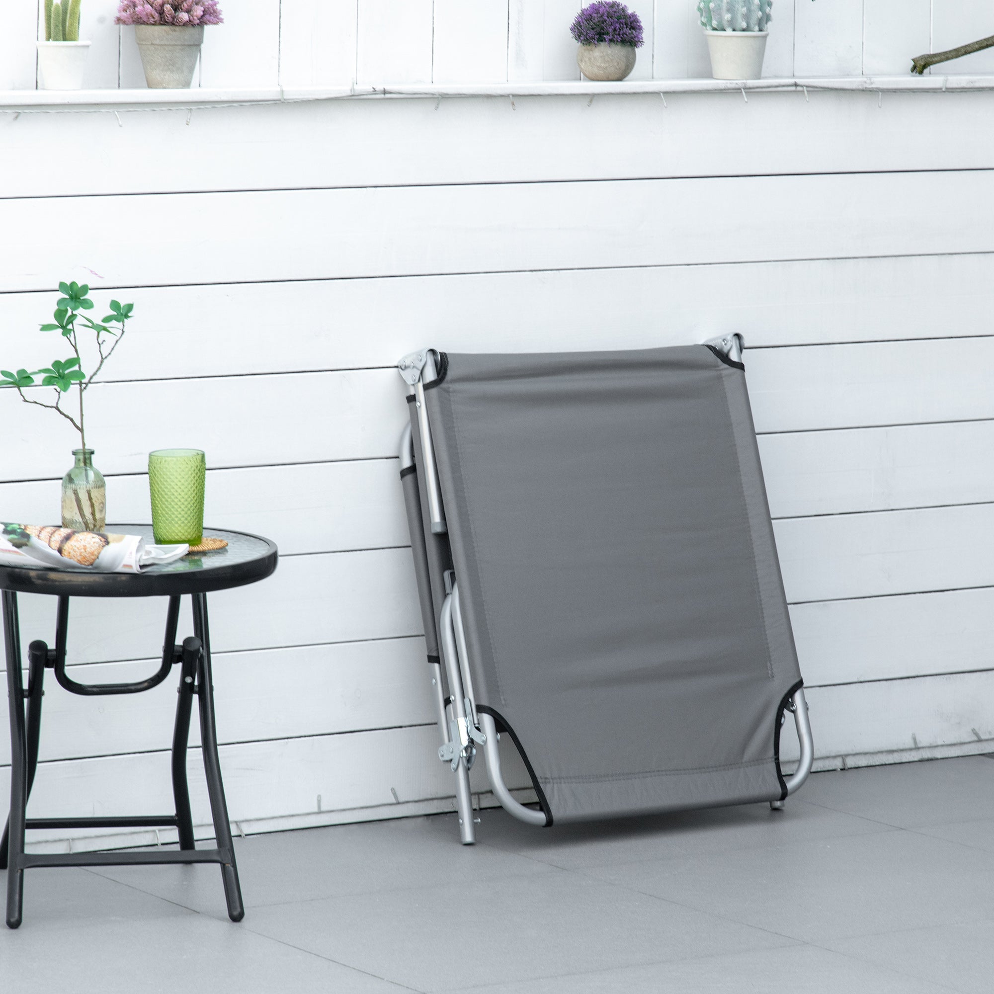 Gray fabric folding camping bed with silver frame and 4-position backrest perfect for outdoor activities and reclining sun lounger