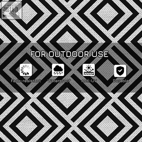 Black and white geometric patterned outsunny reversible outdoor rug made of woven plastic straw with carry bag for camping