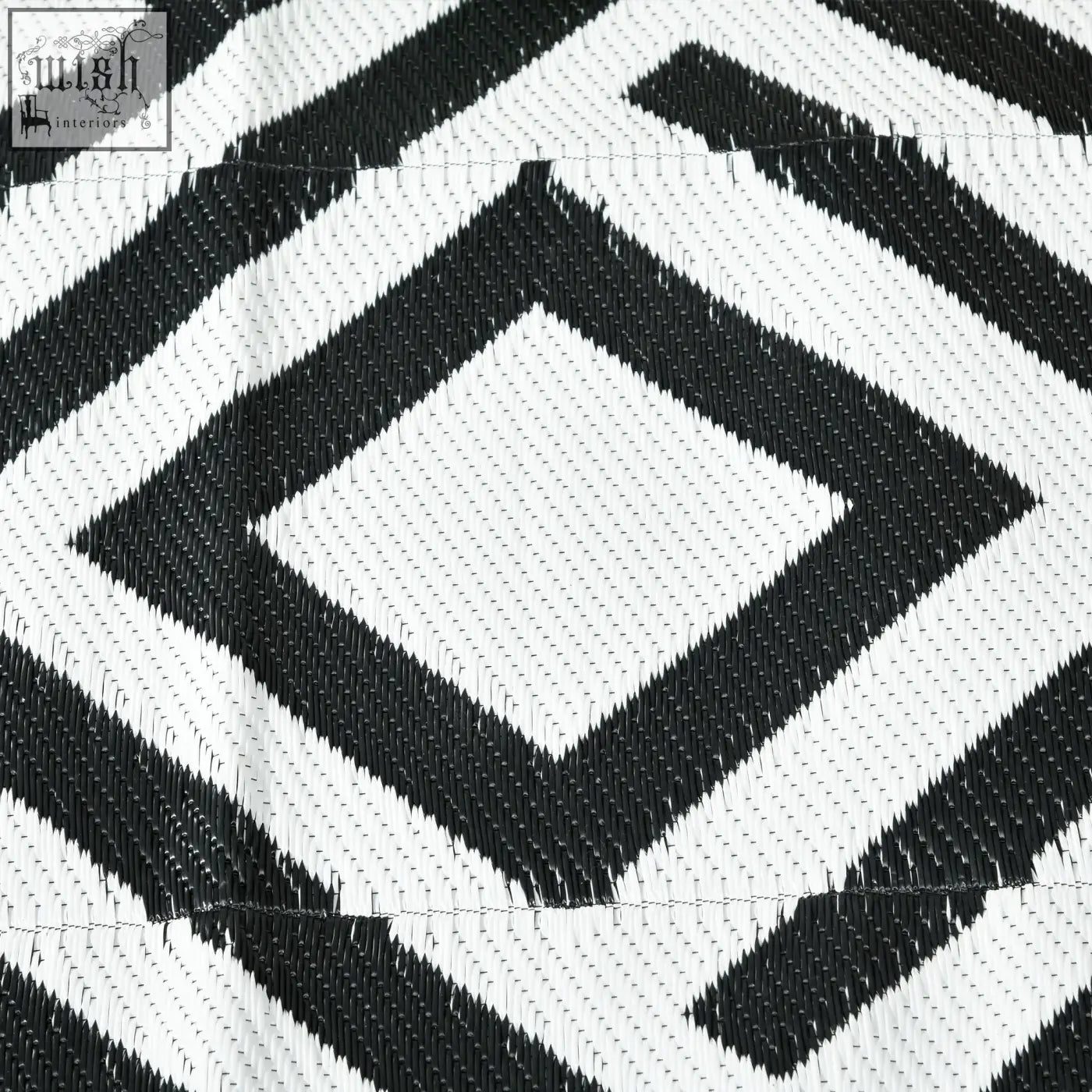 Black and white geometric patterned outsunny reversible outdoor rug made of plastic straw with carry bag and ground stakes