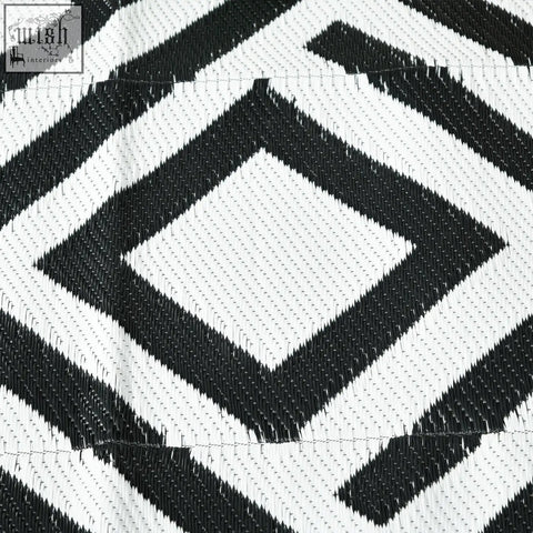 Black and white geometric patterned outsunny reversible outdoor rug made of plastic straw with carry bag and ground stakes