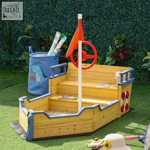 Yellow wooden pirate ship sand pit made of fir wood with blue trim red wheel life preserver for outdoor play