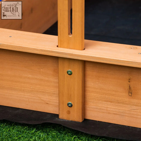 Light brown kids wooden sandbox frame with vertical slats and green screws supporting plastic basins bottomless design