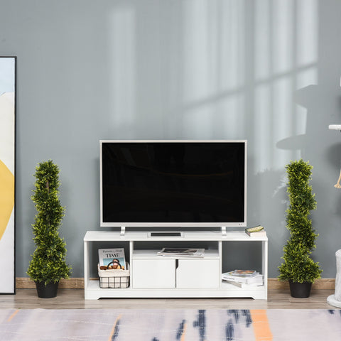 White modern tv stand with open shelves and cabinet doors flanked by green spiral topiary artificial plants in pots