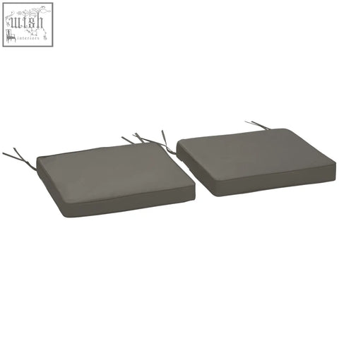 Two dark grey outdoor furniture cushions with polyester fabric covers and two tie fastenings for secure seating