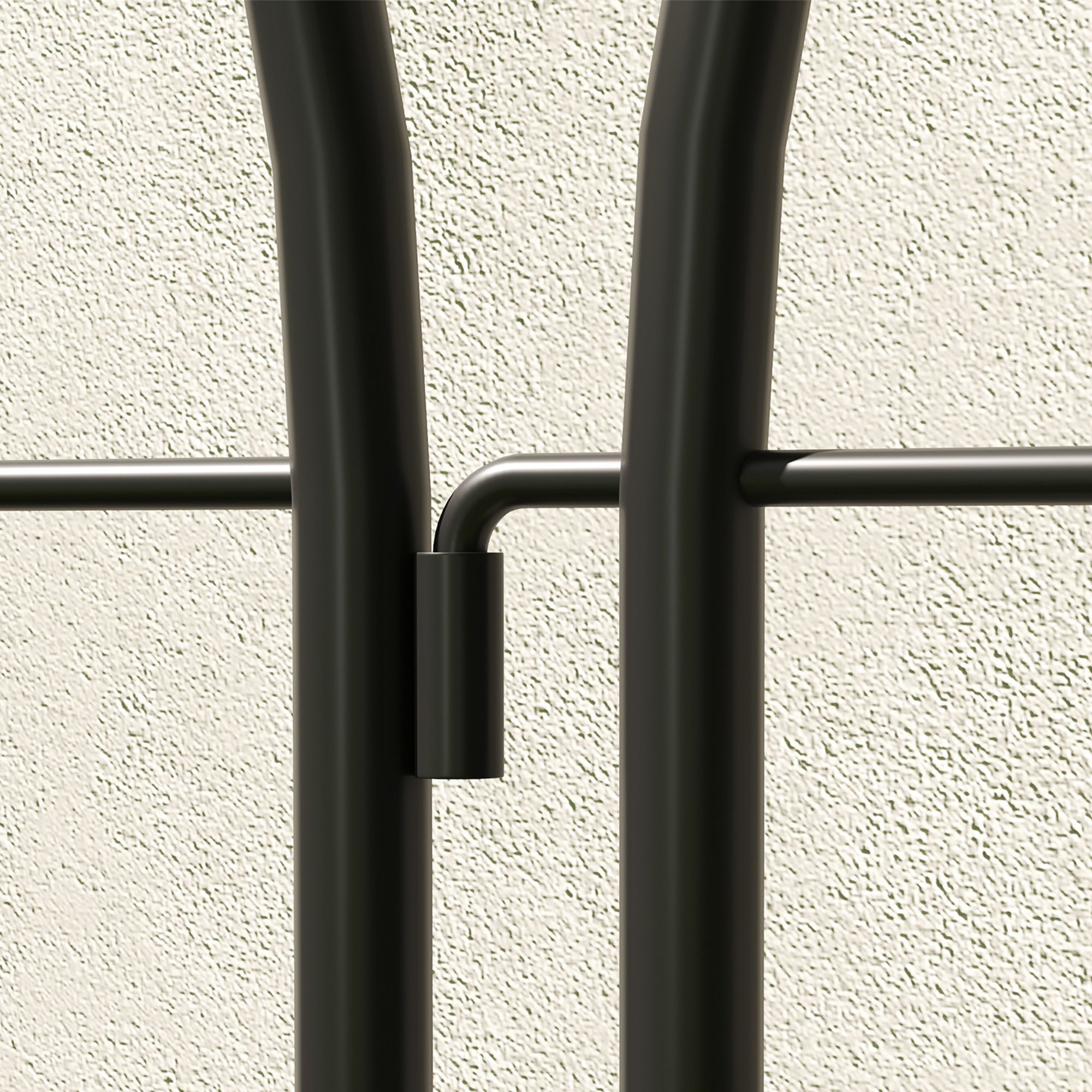 Black metal coat rack with sleek curved bars and minimalist design offering lots of space for hanging coats and bags