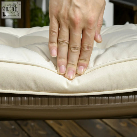 Cream-colored tufted garden seat cushion with textured fabric cover and ribbed brown base featuring two tie fastenings for outdoor seating
