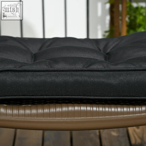 Black tufted outdoor cushion with textured fabric and two tie fastenings for secure outdoor seating comfort