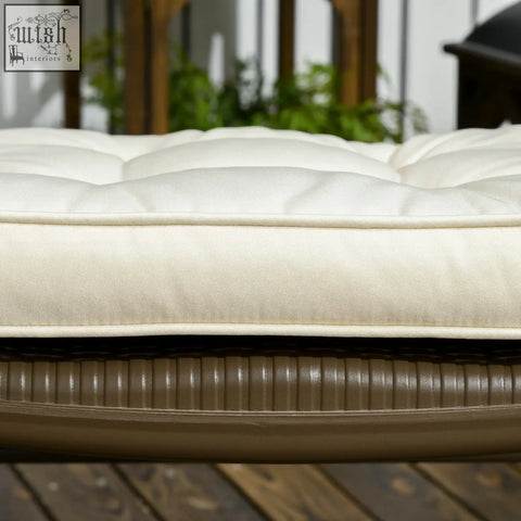 Cream outdoor seating cushion with two tie fastenings made of woven fabric and dark brown wicker base for dining chairs
