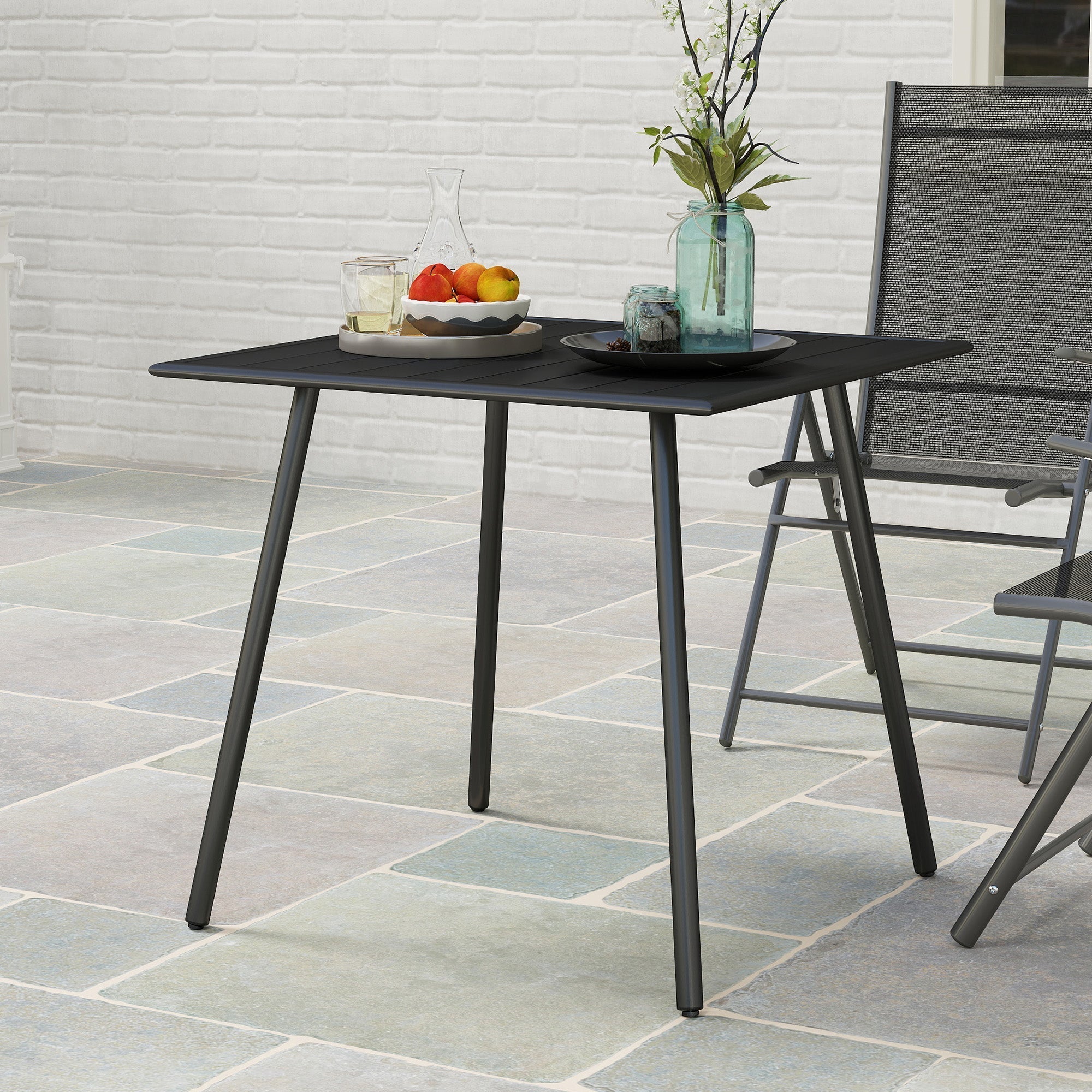Black metal garden table with slat top and powder-coated steel frame for outdoor use seating 4 people