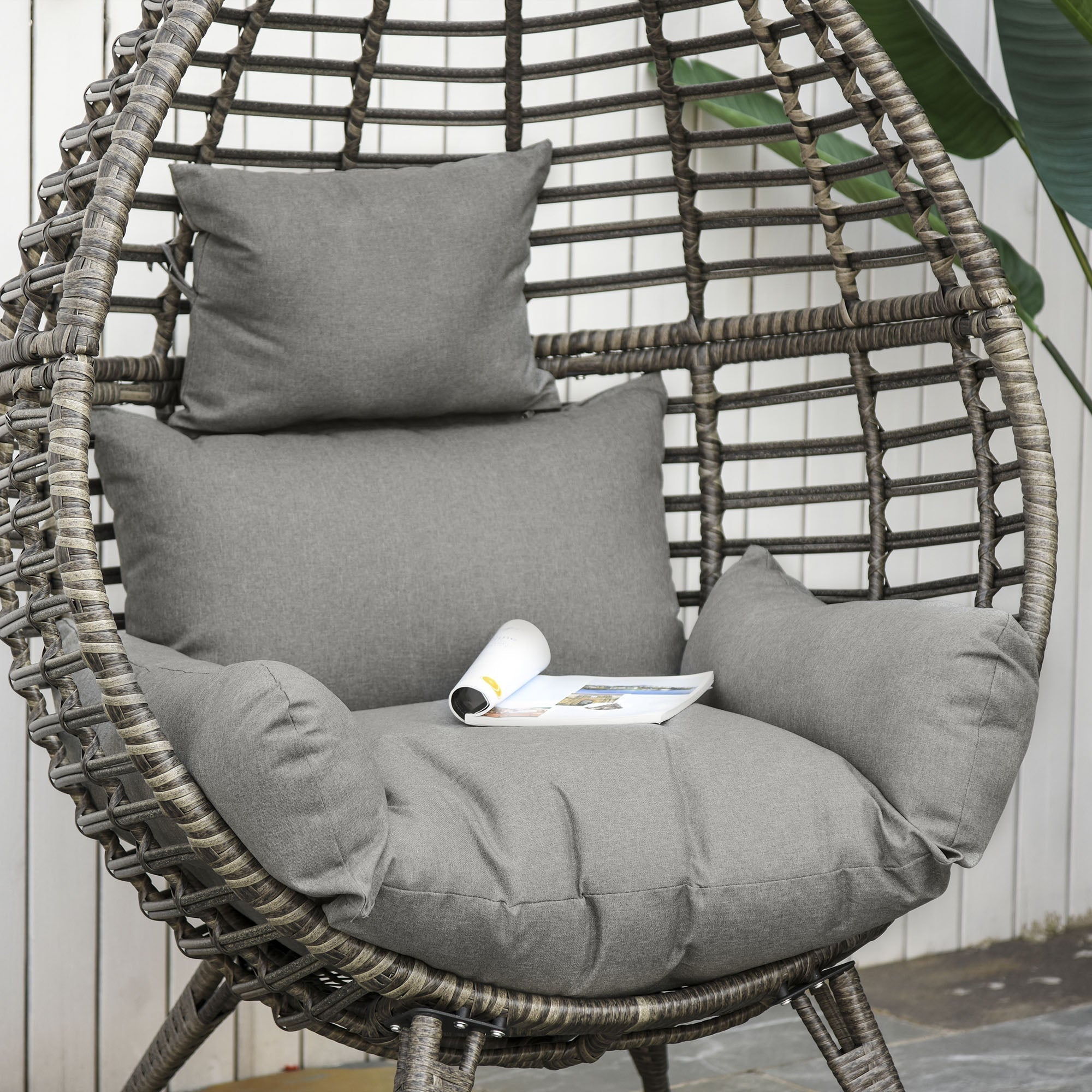 Gray woven wicker lazy chair with thick cushions and 4 legs perfect for outdoor garden seating