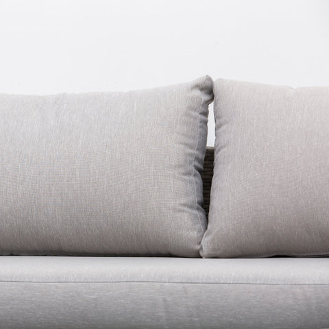 Two light gray textured fabric throw pillows on the outsunny three person sofa rattan set with glass tables