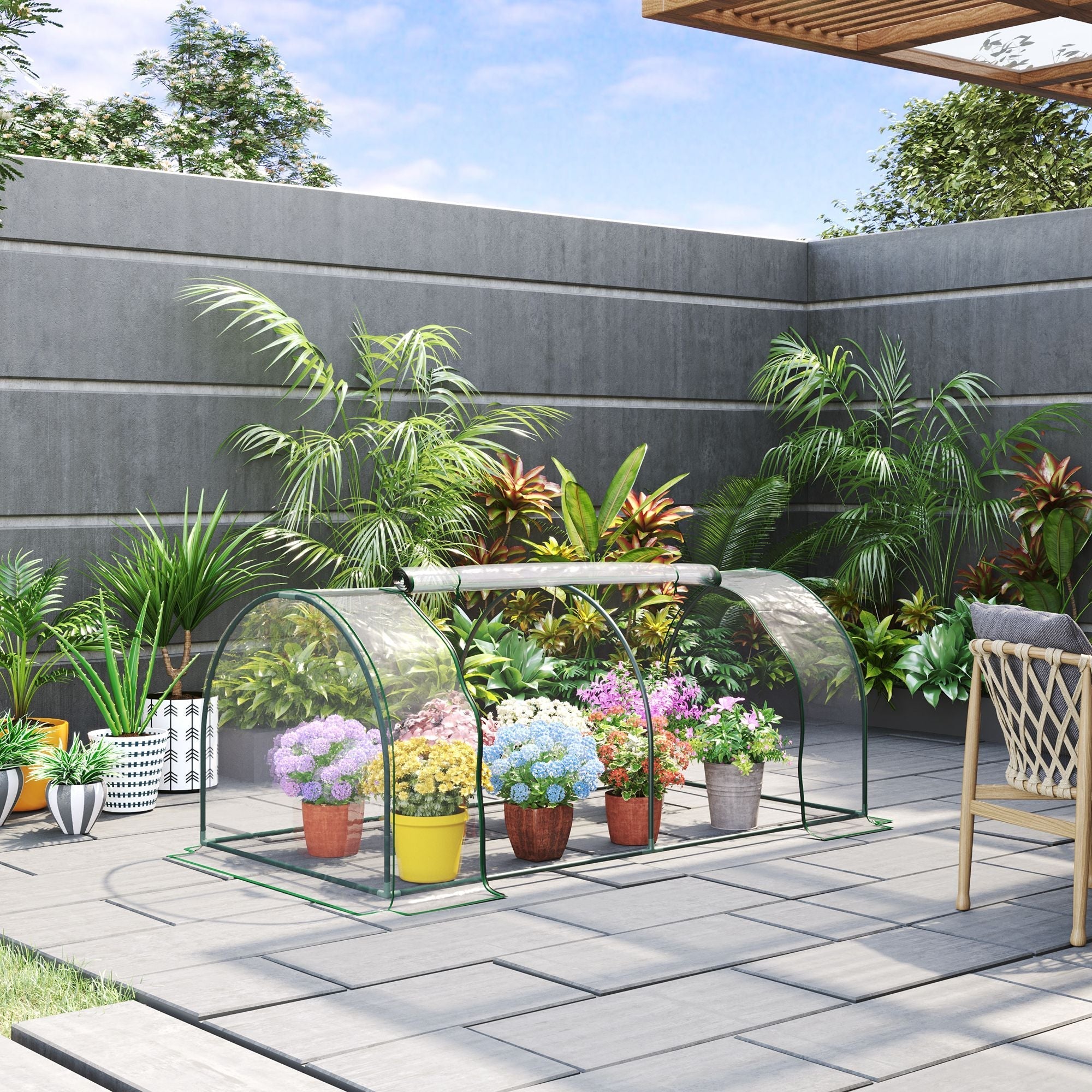 Clear plastic greenhouse with powder-coated steel frame housing colorful flowers for outdoor garden use
